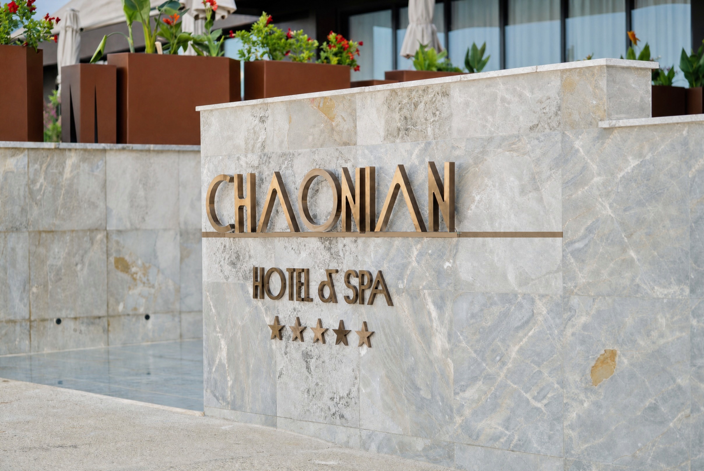 Chaonian Hotel — bronze lettering on the marble arrival wall