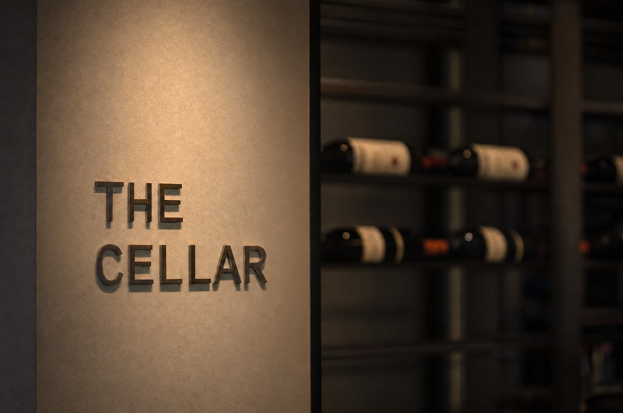 The Cellar — brass lettering above the wine racks