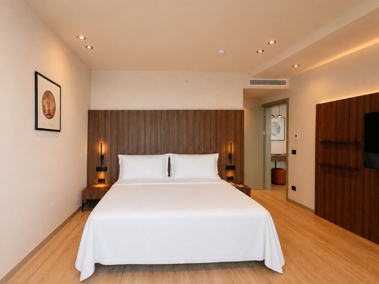 Signature Suite — the main bedroom behind its walnut headboard wall